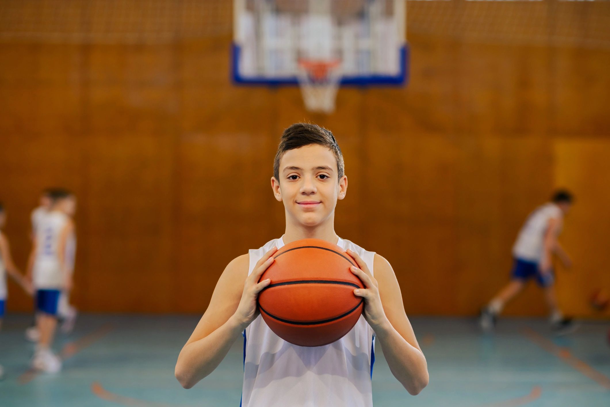 Coach Sarah smiling with a basketball